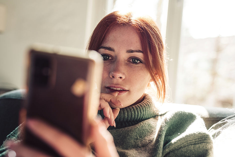 Frau an Smartphone informiert sich über die Preise